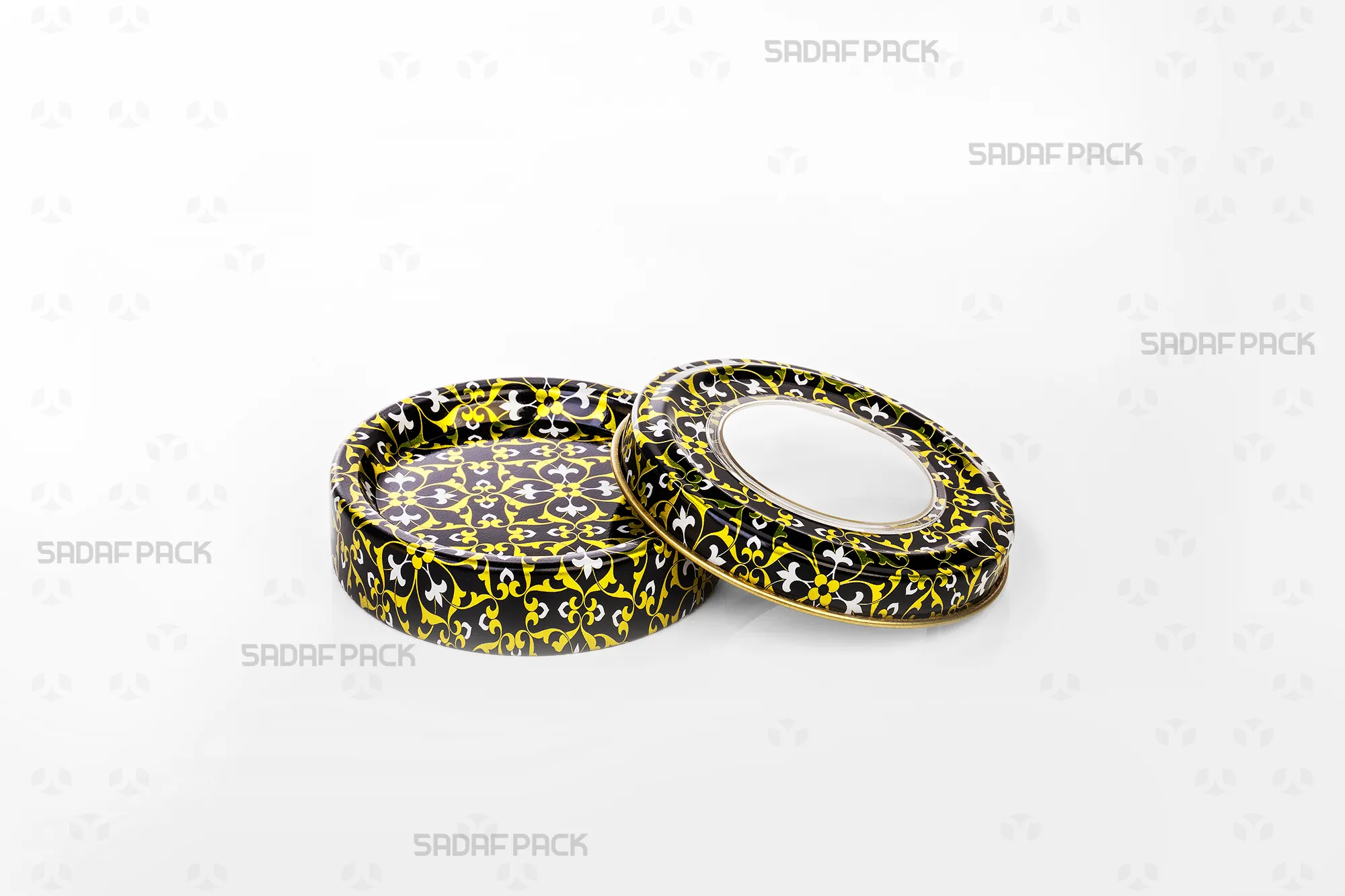Top view of the empty Sadaf Pack 3 gram metal tin and its lid, showcasing the intricate black, gold, and white pattern and the container's interior.