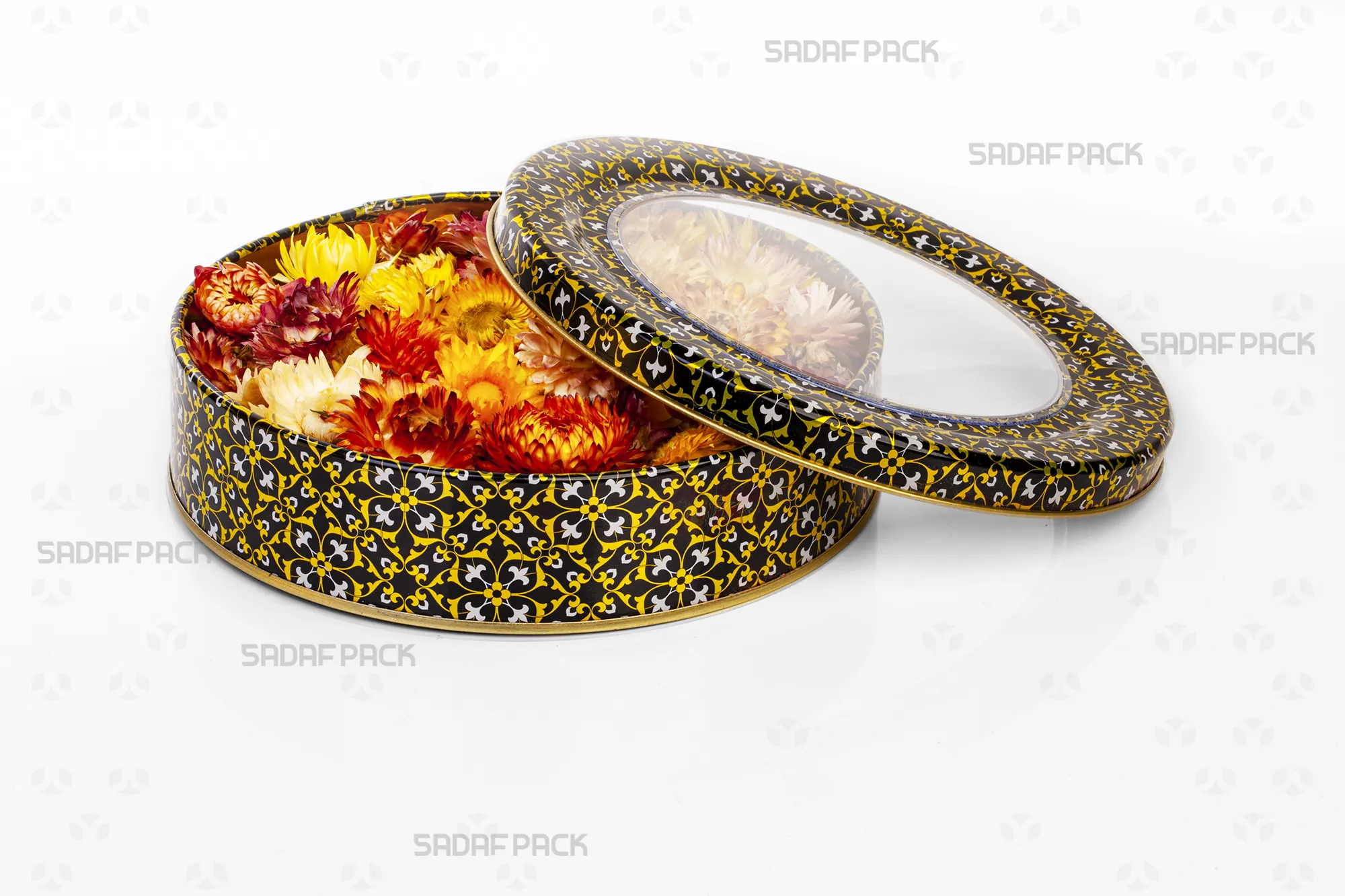 Top-down view of the Sadaf Pack 17cm x 3cm round metal tin, showing the open lid and base with the black, gold, and white design, filled with dried decorative flowers to display capacity.