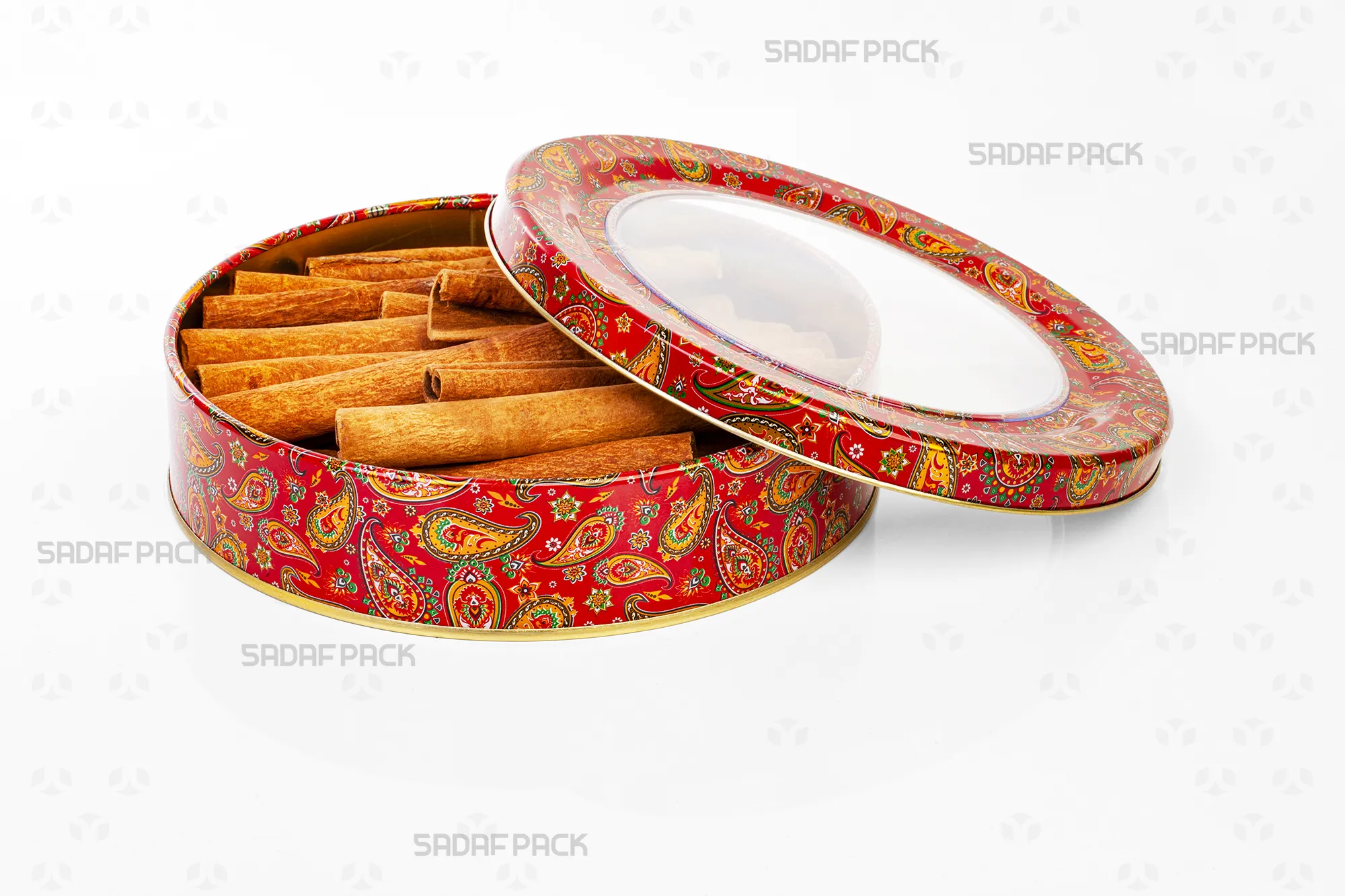 Top-down view of the Sadaf Pack 17cm x 3cm round metal tin, showing the open lid and base with the red Termeh design, filled with cinnamon sticks to display capacity.
