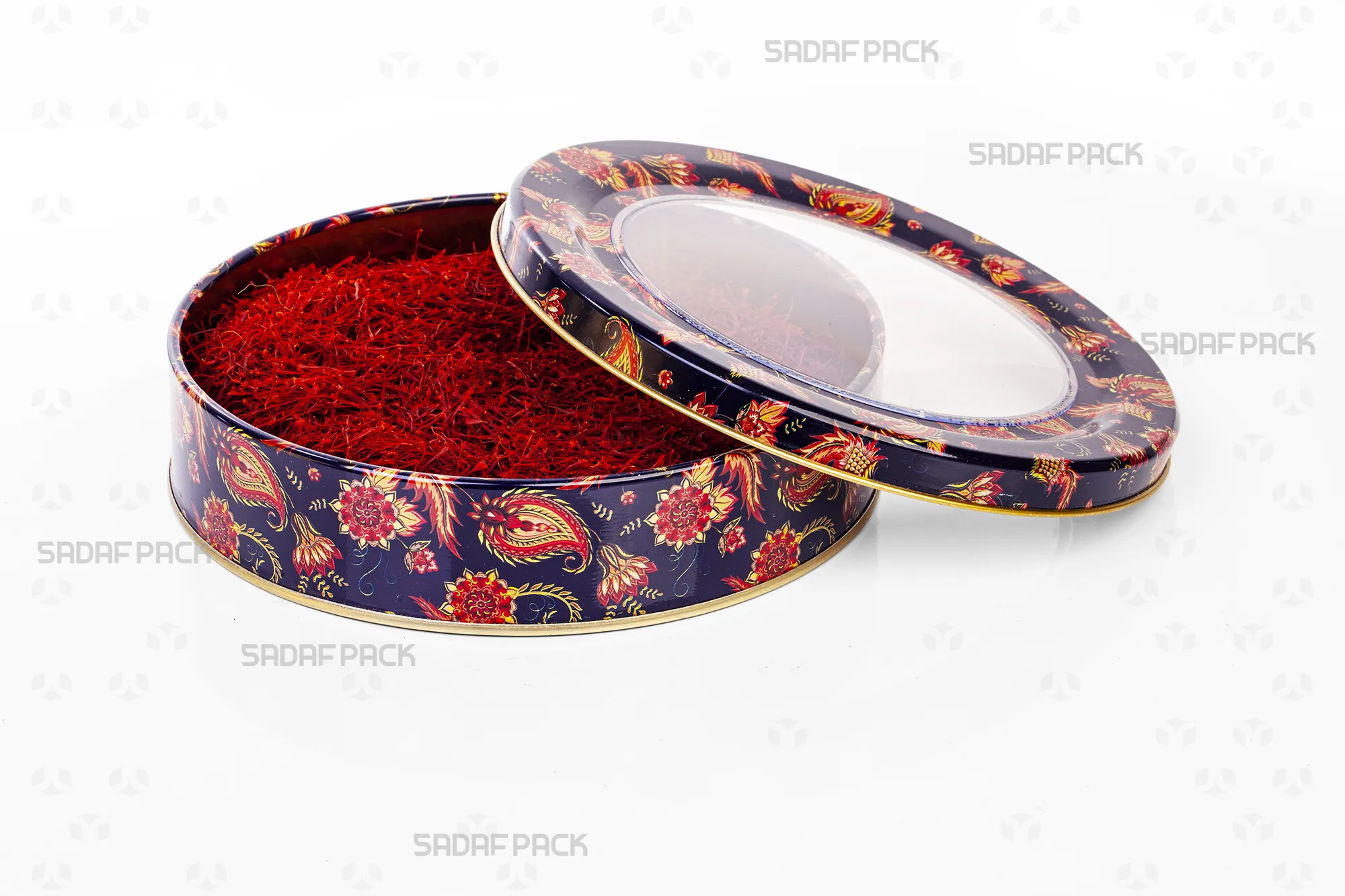 Top-down view of the Sadaf Pack 17cm x 3cm round metal tin, showing the open lid and base with the navy blue Toranj design, filled with saffron threads to demonstrate capacity.
