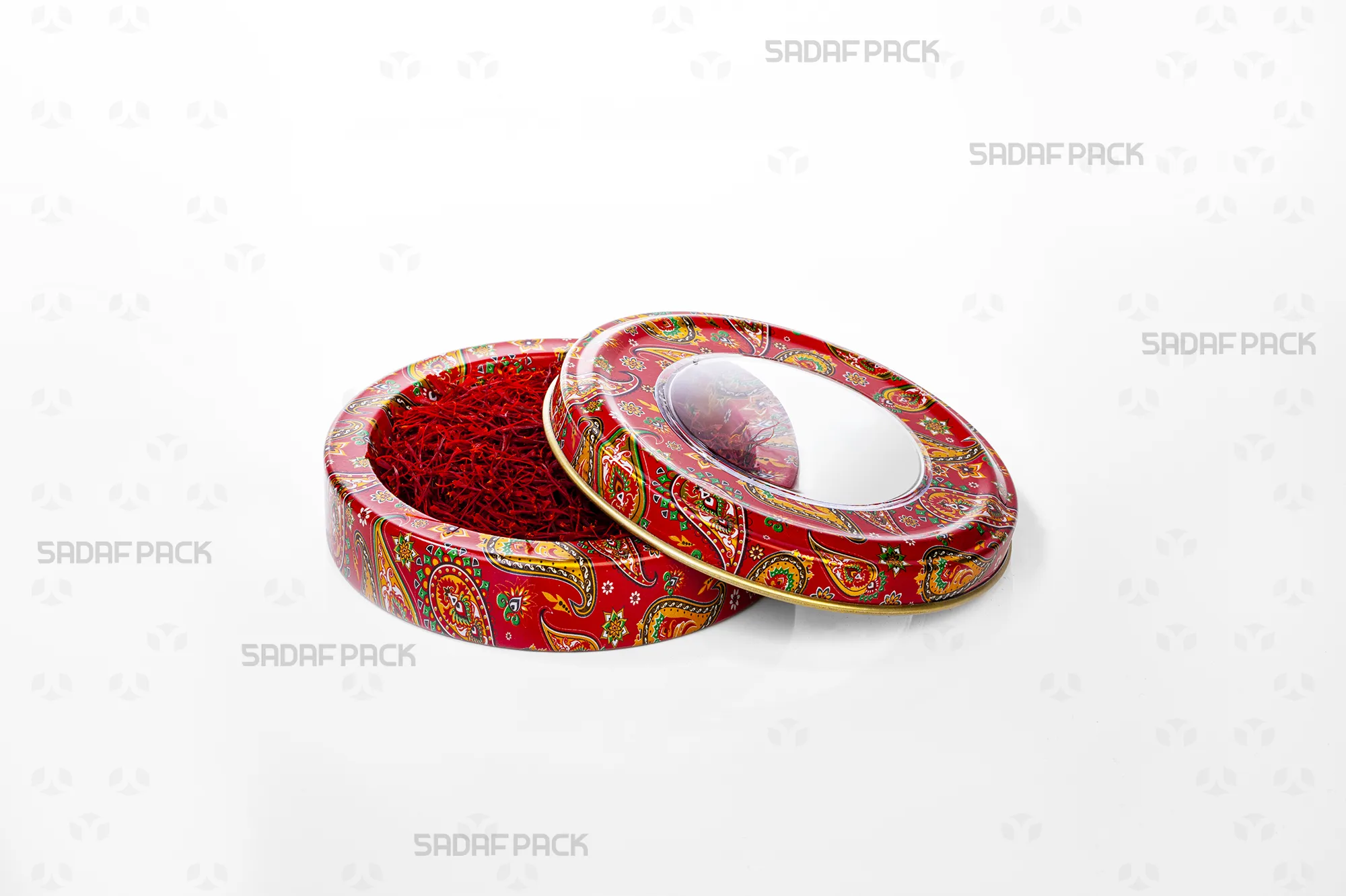 منظر علوي للعلبة المعدنية سعة 5 جرام من صدف باك بنقش "الترمة الأحمر" (بيزلي)، تظهر بغطاء مفتوح ومملوءة بخيوط الزعفران.