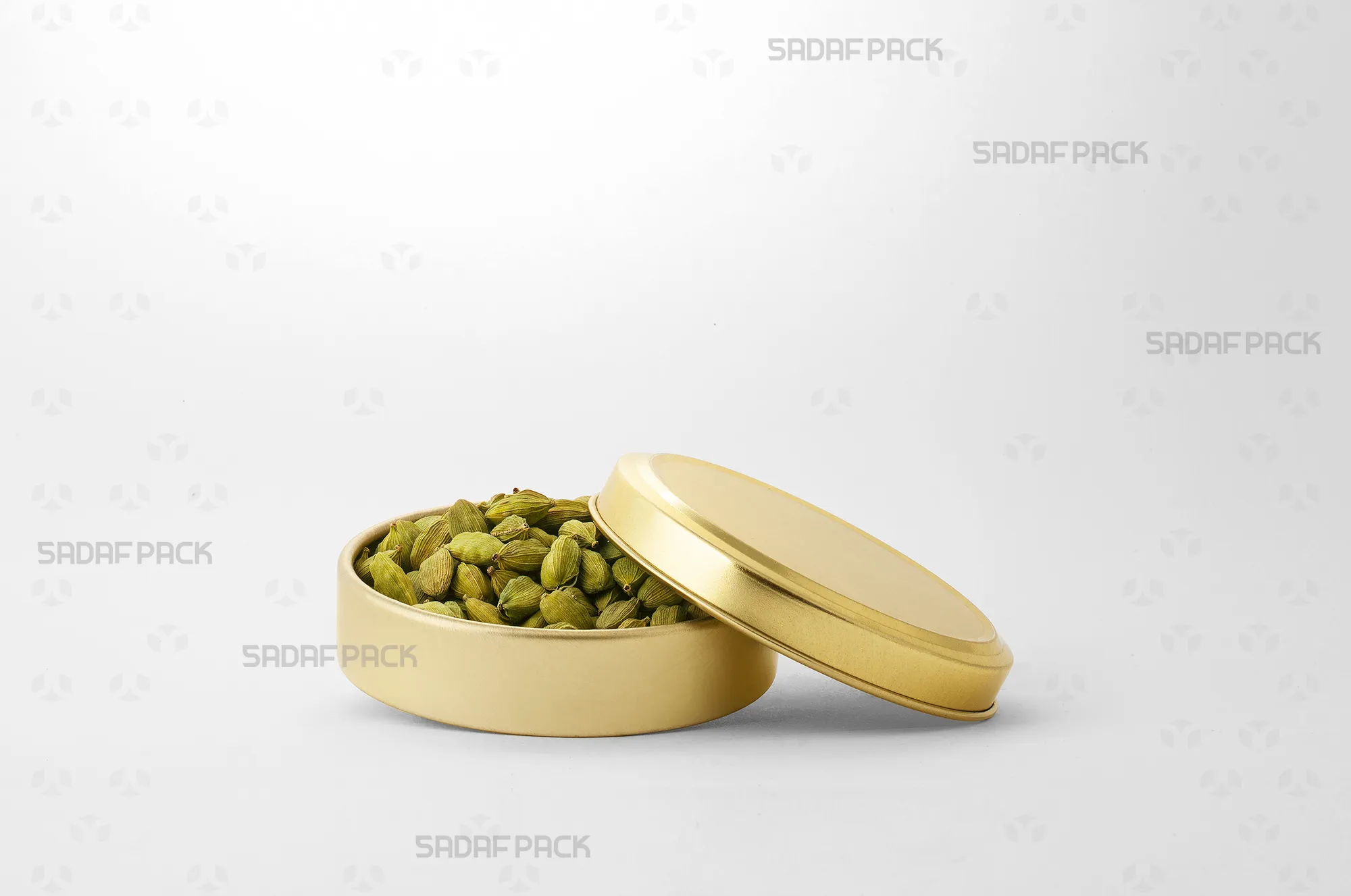 The Gold 9 Metal 2 cm Tin (200 Metal) filled with cardamom, demonstrating its suitability for premium, light-protected packaging.
