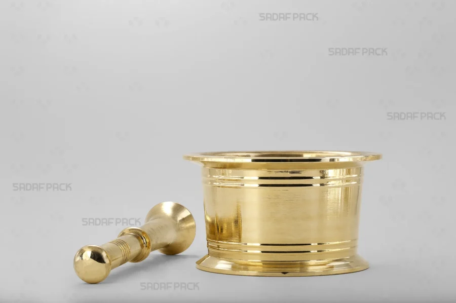 The Traditional Brass Mortar 110 is displayed from a front angle with its matching brass pestle resting beside it, highlighting the complete set for grinding and its suitability as a luxurious gift.