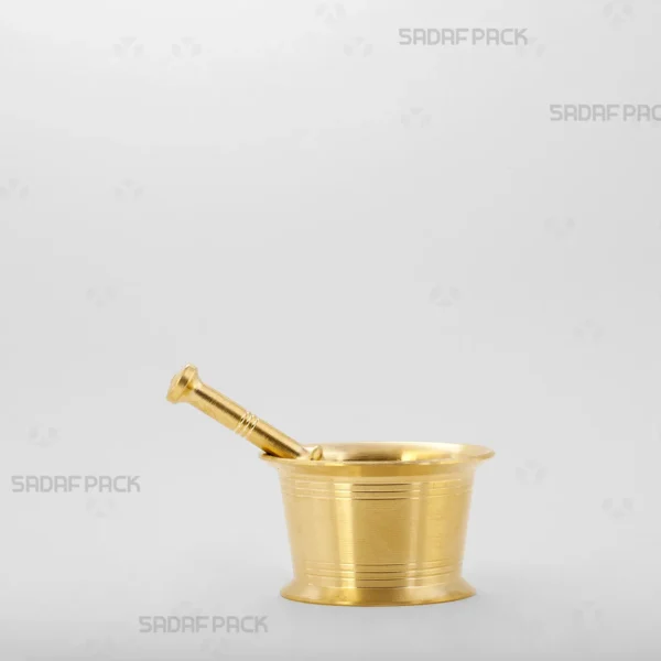 A front-facing view of the Sadaf Pack Traditional Brass Mortar 65, highlighting its heavy, cylindrical shape and the detailed circular lines engraved on its body, designed for grinding saffron and spices.