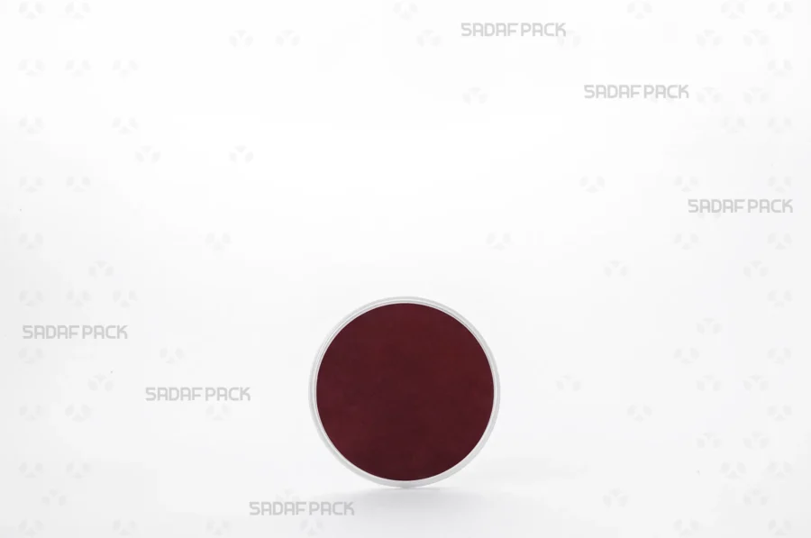 Three-quarter angle view of the 6.5 Slim España round poly-crystal container with crimson Cardboard Pad 6.5 inside container