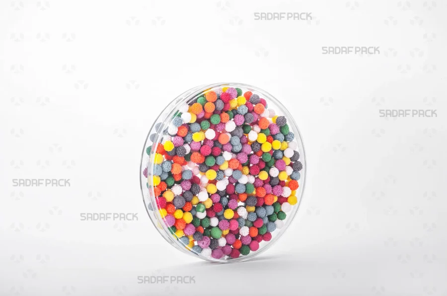 A three-quarter angle view of the 12 Core Crystal Container filled with sprinkles, demonstrating its suitability for export-quality packaging.