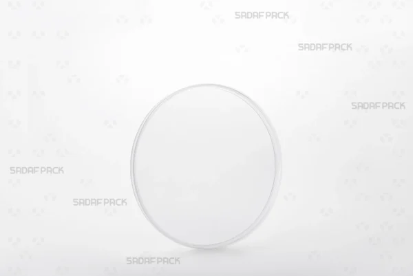 A three-quarter angle view of the Sadaf Pack 12 Flat Crystal container, a clear circular container designed for premium saffron and spice packaging.