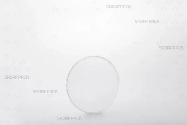 A three-quarter angle view of the 9.5 Flat Crystal container by Sadaf Pack, showcasing its clear, circular design ideal for premium saffron packaging.