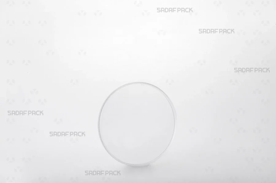 A three-quarter angle view of the 9.5 Flat Crystal container by Sadaf Pack, showcasing its clear, circular design ideal for premium saffron packaging.
