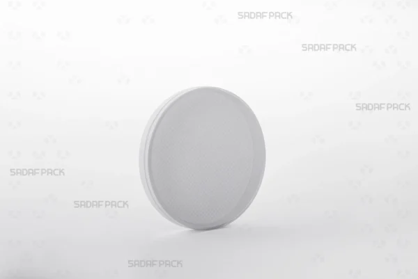 Three-quarter angle view of the round 9 España crystal container from Sadaf Pack, designed for premium saffron packaging.