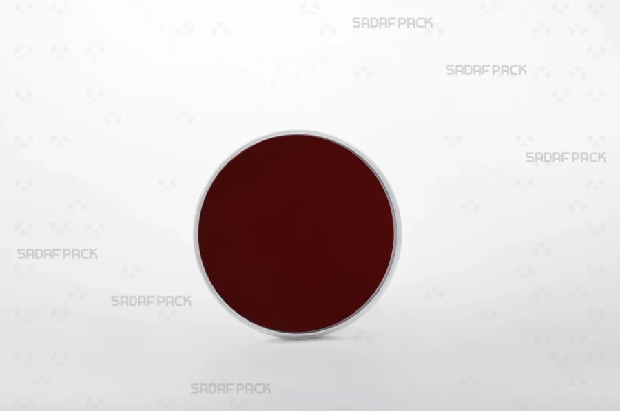 Three-quarter angle view of the 9 España round poly-crystal container with crimson Cardboard Pad 9 inside container