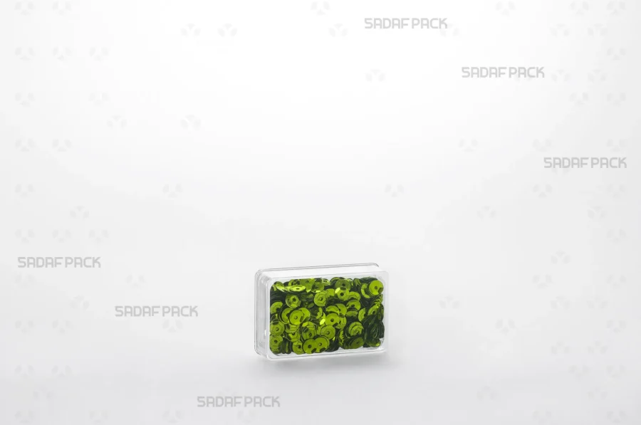 An elegant display of the 4 Deep Crystal Rectangle container filled with green sequins, making it a perfect choice for export products.