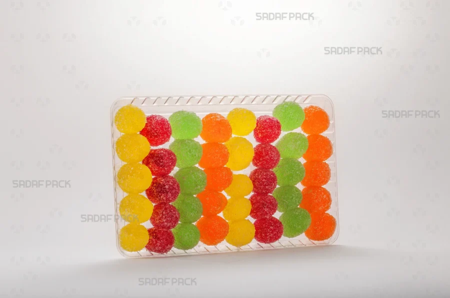 The Crystal Rectangle Tray 100 presented with an arrangement of Gummy Candies, demonstrating its suitability for export-quality gift packaging. 