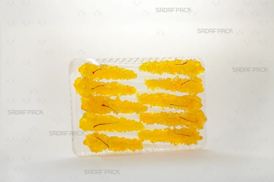 The Crystal Rectangle Tray 100 presented with an arrangement of saffron rock candy, demonstrating its suitability for export-quality gift packaging. 