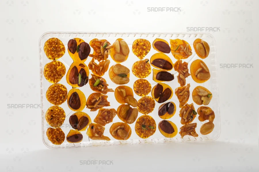The Crystal Rectangle Tray 150 is presented filled with delicate Honey Brittle, emphasizing its suitability for luxury food products and pilgrimage souvenirs.