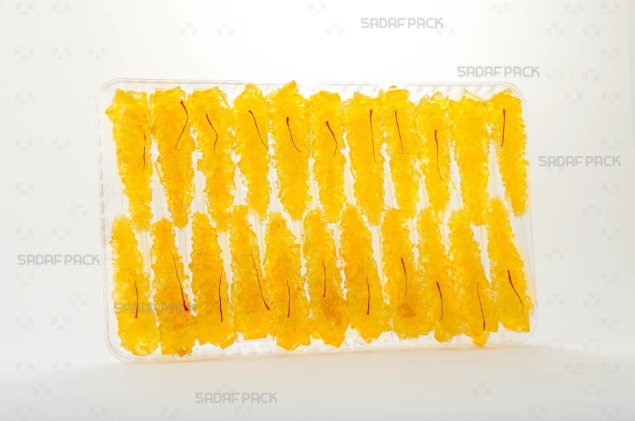 The Crystal Rectangle Tray 150 is presented filled with delicate saffron rock candy, emphasizing its suitability for luxury food products and pilgrimage souvenirs.
