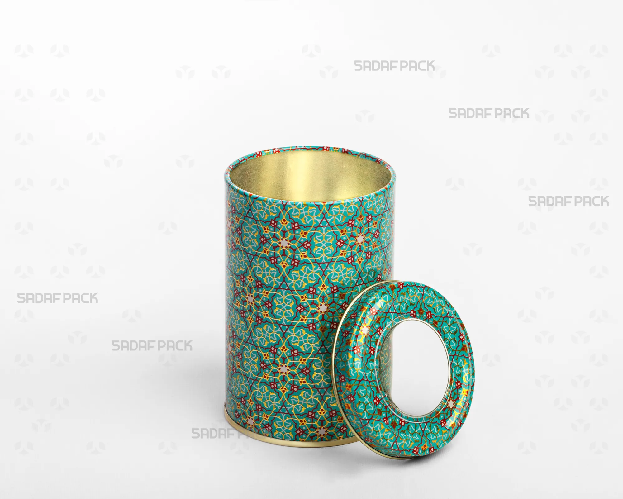 A three-quarter angle view of the Sadaf Pack 7cm diameter by 10cm height metal tin with an open lid, showcasing the Turquoise (Firoozeh) pattern and the clear polycrystal window on the separated lid.