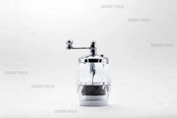 A front view of the Sadaf Pack Crystal Saffron Grinder - Six Corners model, showcasing its transparent hexagonal crystal body, chrome-plated metal cap, and ergonomic rotary handle, expertly designed for grinding saffron threads into a fine, uniform powder.