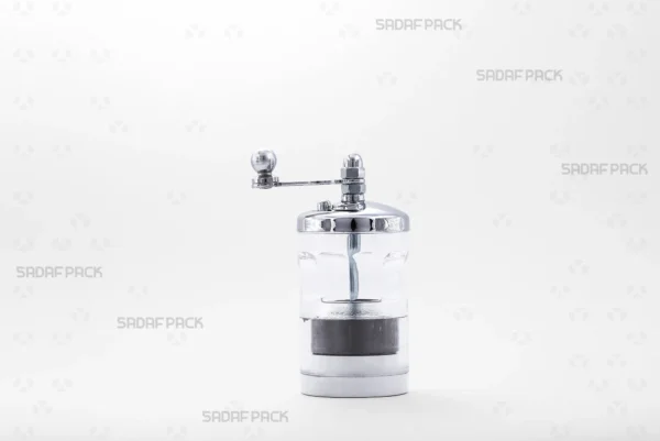 A front view of the Sadaf Pack Round Crystal Saffron Grinder, highlighting its transparent body which allows visibility of the contents, chrome-plated metal cap, and ergonomic rotary handle designed for grinding saffron and other spices.