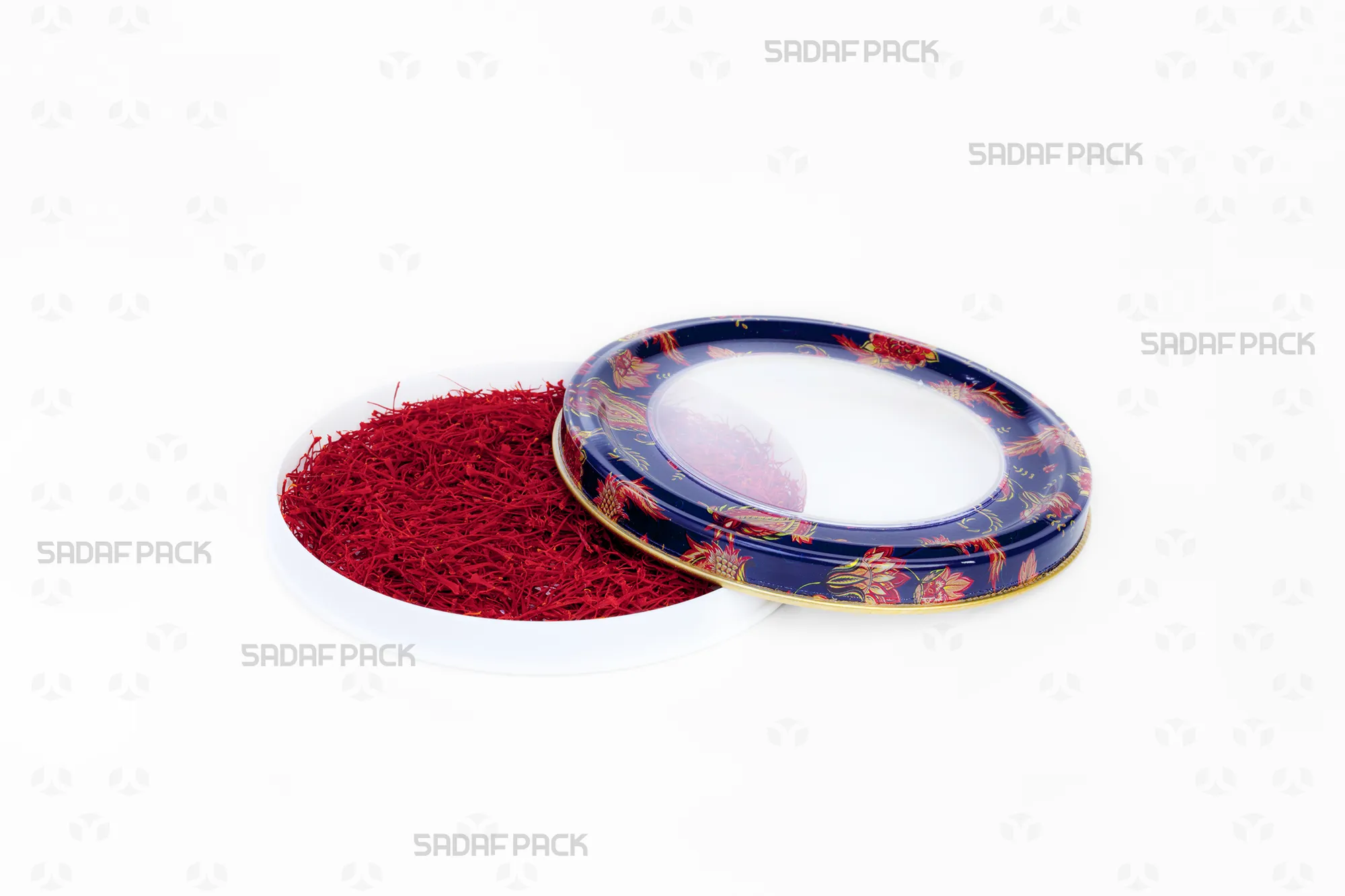 منظر علوي لعبوة صدف باك المعدنية "12 ميتال إسبانيا ذات قاع مسطح" وغطاؤها مفتوح، تُظهر تصميم "الترنج الكحلي" وسعتها الممتلئة بالزعفران.