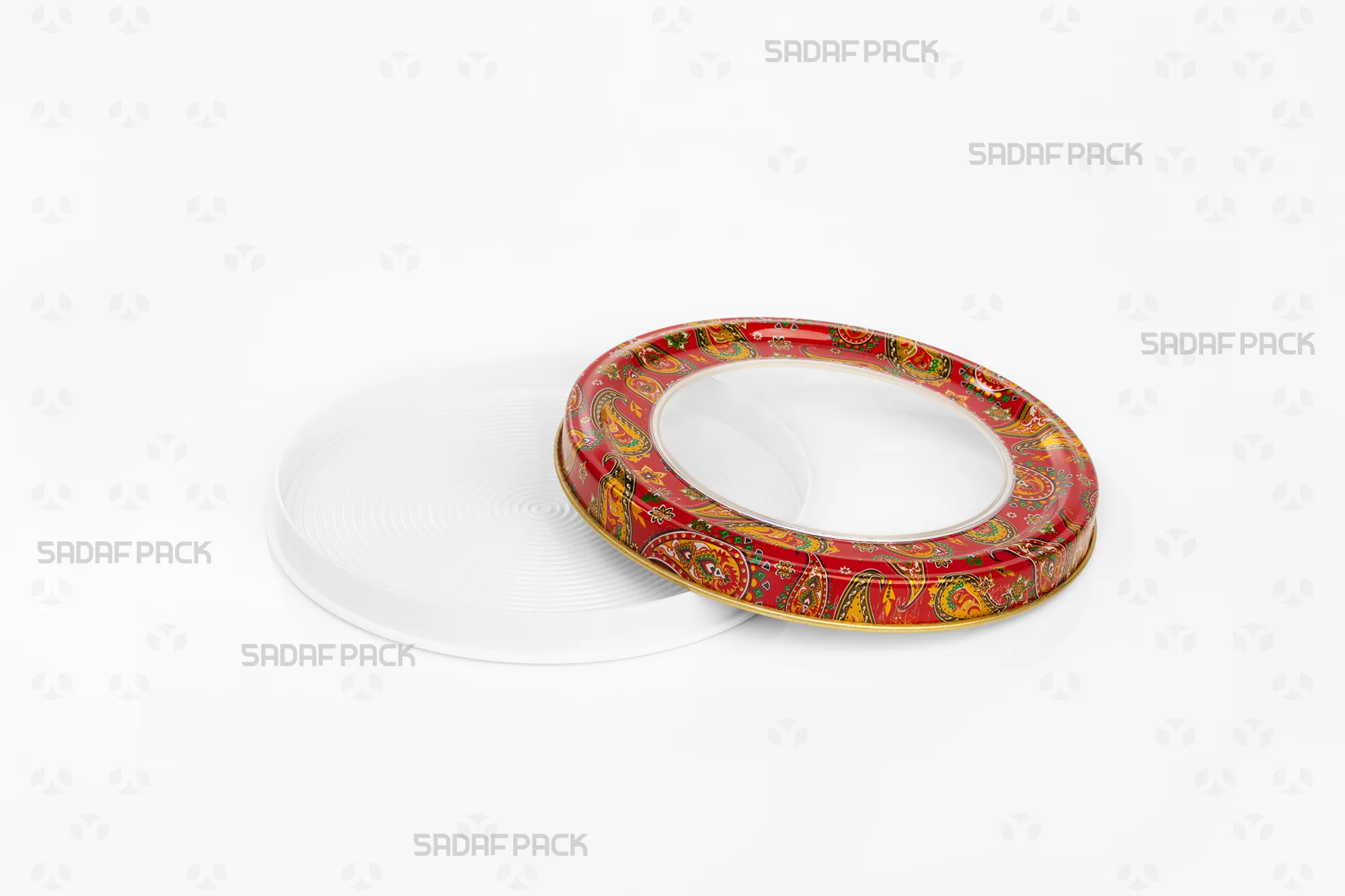 منظر علوي لعبوة صدف باك المعدنية الفارغة "12 ميتال إسبانيا ذات قاع مسطح" والغطاء مفتوح، يُبرز نمط "الترمة الأحمر" (البيزلي) التقليدي وسعة العبوة الداخلية.