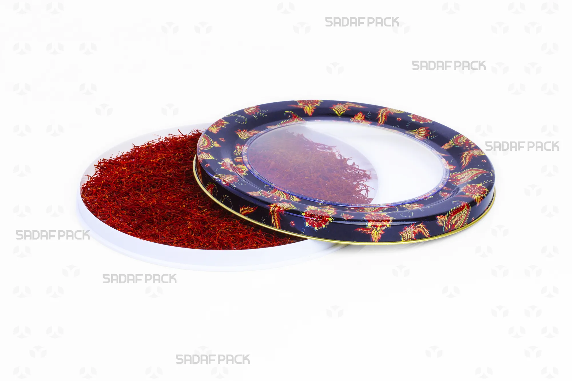 Top-down view of the 17 Metal España Raised Bottom tin by Sadaf Pack, showing the open lid beside the base filled with saffron, highlighting the navy blue Toranj pattern.